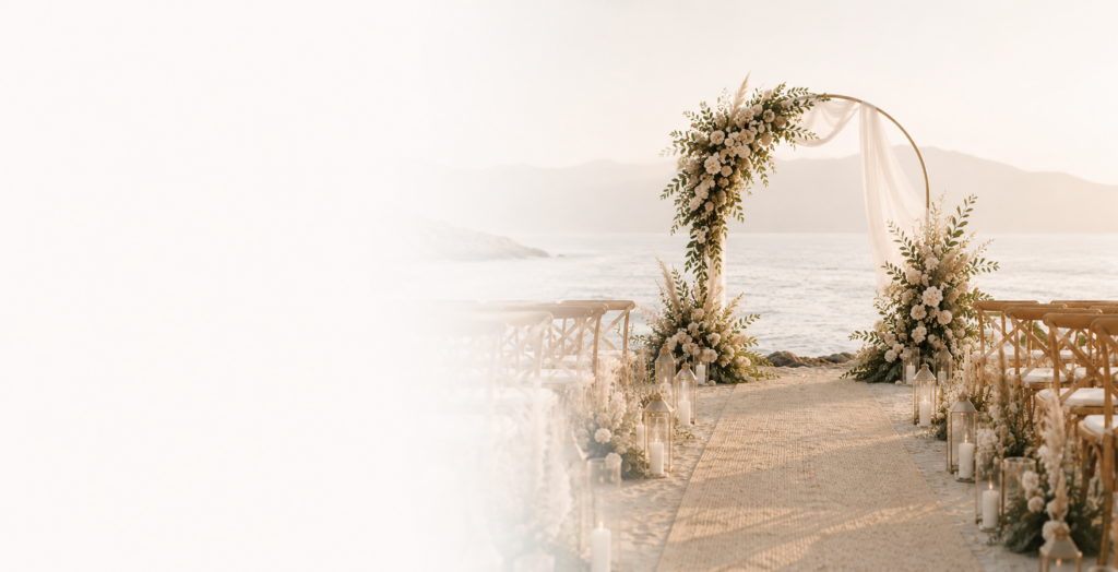 Arche de cérémonie ronde dorée avec voilage blanc et décoration florale, installée pour un mariage bohème en bord de mer.